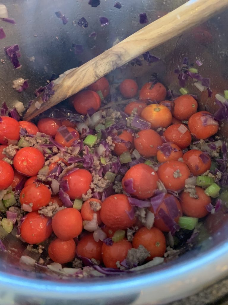 adding cherry tomatoes to veggie beef soup