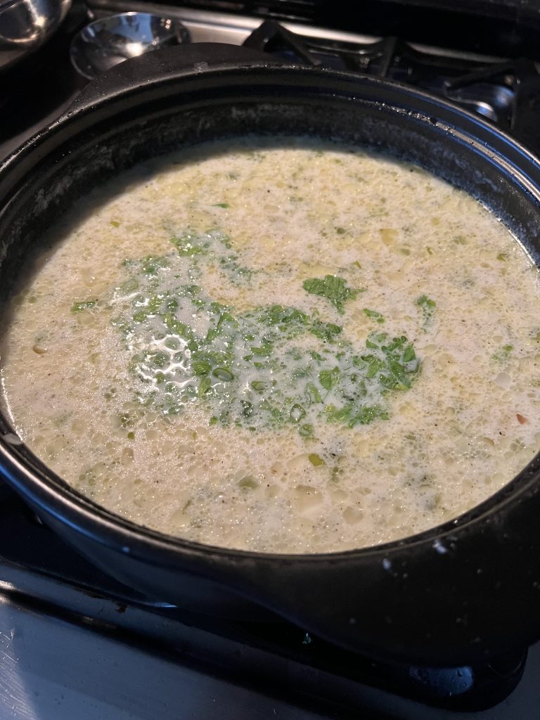 Adding the celery and green onion tops to the potato soup